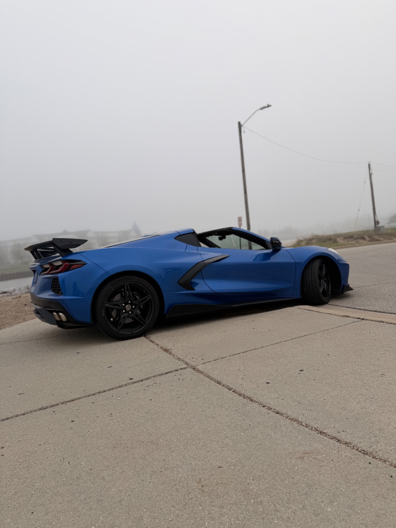 Rear profile of the blue Corvette C8 with high-wing spoiler